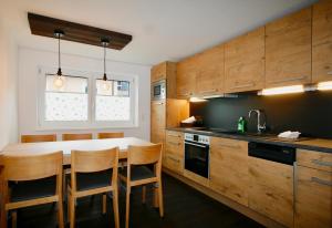 a kitchen with wooden cabinets and a table and chairs at Ferienhaus Sonnberg in Hüttau