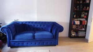 a blue couch in a living room with a book shelf at Appartment Porte de Versailles Paris Expo in Issy-les-Moulineaux
