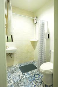 a bathroom with a toilet and a sink at Baan Wangderm Hotel in Bangkok