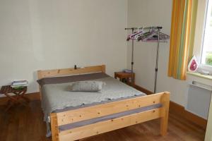 - une chambre avec un lit en bois dans l'établissement Les Jonquilles, à La Bresse