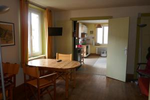 um quarto com uma mesa e cadeiras e uma cozinha em Les Jonquilles em La Bresse