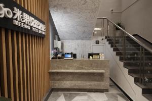 a lobby with a staircase in a building at Meego Yes Hotel in Shanghai