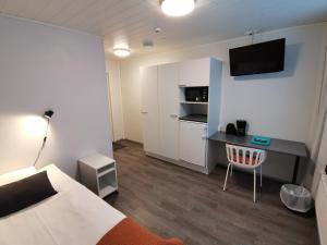a room with a bed and a desk with a computer at LODGE Aparthotel Raahe in Raahe