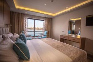 a hotel room with a large bed and a table at SUNRISE Semiramis II Cruise in Luxor