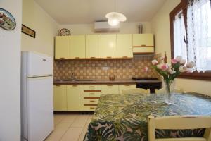 a kitchen with a table with a vase of flowers on it at Margherita Monolocale in Marina di Campo +10 photos