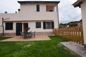 a patio with a table and chairs in front of a house at Margherita Monolocale in Marina di Campo