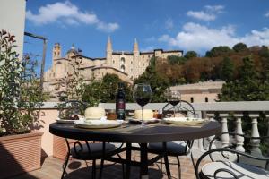 stół z dwoma kieliszkami wina na balkonie w obiekcie Balcone sulle Meraviglie w mieście Urbino