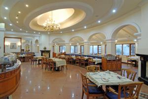 a restaurant with tables and chairs and a chandelier at KTDC Tea county in Munnar