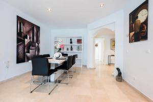 a dining room with a table and black chairs at Charming 2 Bedroom Trocadero Arena area in Marbella