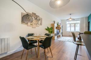 a dining room and living room with a table and chairs at Résidence Sénac in Valenciennes