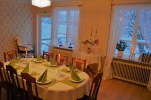 un comedor con una mesa con mesas y sillas blancas en River Lodge, en Ludvika