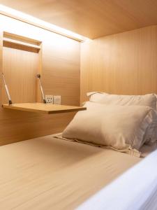 Dormitorio con cama con espejo y estante en M Boutique Hostel Legian, en Legian