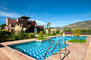 a swimming pool in front of a house at Les Jardins Yasmina Bin el-Ouidane in Bine el Ouidane