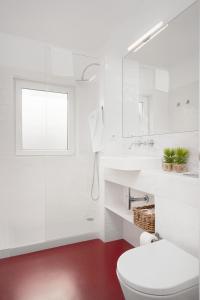 a white bathroom with a toilet and a sink at Oporto Classic Pàtio in Porto
