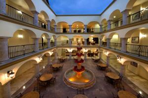 eine leere Lobby mit einem Brunnen sowie Tischen und Stühlen in der Unterkunft Las Villas Hotel & Golf By Estrella del Mar in Mazatlán