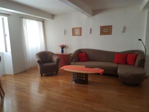 ein Wohnzimmer mit einem Sofa, einem Stuhl und einem Tisch in der Unterkunft Your Home In Vienna in Wien