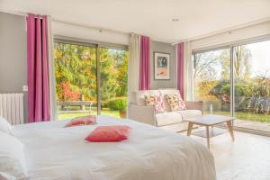 a bedroom with a bed and a couch and windows at La Maison de l'Orbière in Forcé