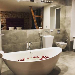een badkamer met een groot wit bad met bloed erop bij Cinema Apartments in Poznań