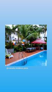 a pool at a resort with tables and chairs at Manuela Residence in Lagos