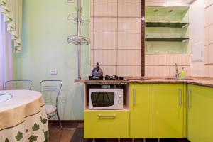 a kitchen with yellow cabinets and a microwave on a counter at Apartments in a developed area in Dnipro