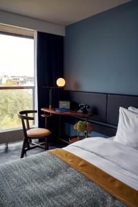 a bedroom with a bed and a desk and a window at Park Centraal Amsterdam, part of Sircle Collection in Amsterdam +28 photos