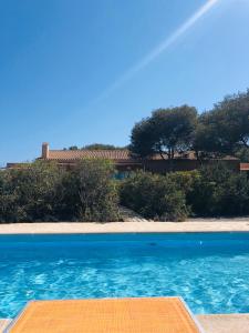 una piscina blu con una casa sullo sfondo di CASA VALENTINA VIVIENDA TURISTICA ET6135 a Es Caló de Sant Agustí