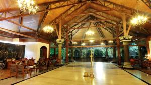 um grande quarto com um grande tecto com lustres em The Mascot Hotel - A Heritage Living Experience em Trivandrum
