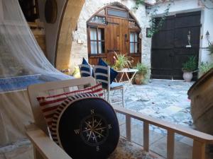 an outdoor patio with a clock on a bench at Stratos ArtDeco House in Kalavasos