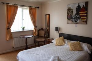 - une chambre avec un lit, une chaise et une fenêtre dans l'établissement Oliver Twist Country Inn, à Wisbech