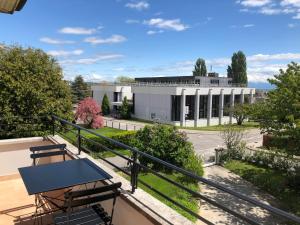 a balcony with a table and chairs and a building at Au Bonheur des Iris in Rolle