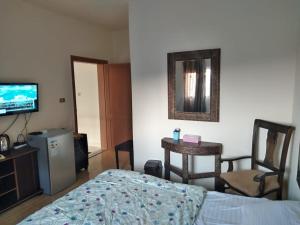 a bedroom with a bed and a tv and a chair at Horizon in Wadi Musa