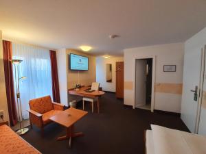 a hotel room with a bed and a desk with a computer at Hotel Gerberhof in Backnang