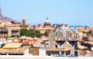 dos vasos de vino tinto sentados en una cornisa en Albergo Athenaeum, en Palermo