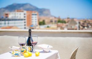 un tavolo con due bicchieri e una bottiglia di vino di Albergo Athenaeum a Palermo