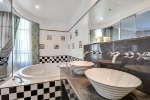 ein Badezimmer mit zwei Waschbecken und einer Badewanne in der Unterkunft Villa Lutèce Port Royal in Paris