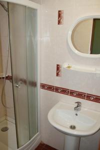 a bathroom with a shower and a sink and a mirror at Отель in Malyn