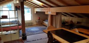 サンモリッツにあるB&B St Moritzの二段ベッドとテーブルが備わる小さな客室です。