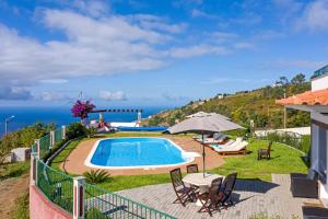 a swimming pool with a view of the ocean at OurMadeira - Theo's House, secluded in Calheta