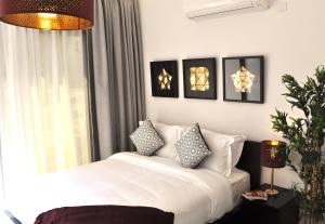 - une chambre avec un lit blanc et des oreillers dans l'établissement Luxury Suite - Amazing Views & Lovely Garden, à Salalah