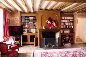a living room with a fireplace and a tv at Chambres d'hôtes La Bergerie de l'Aqueduc in Houx