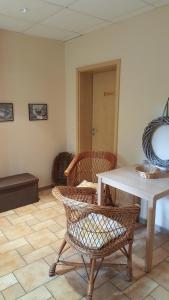 a room with a table and wicker chairs and a table at "Spreehof" Apartmenthaus in Lehde in Lübbenau