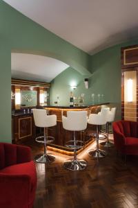 a bar with white stools in a room with green walls at Sea-facing Art Deco Apartment in Brighton & Hove