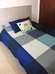 - un lit avec une couette bleue et blanche dans l'établissement PISO 1ª LINEA SANLUCAR DE BARRAMEDA, à Sanlúcar de Barrameda