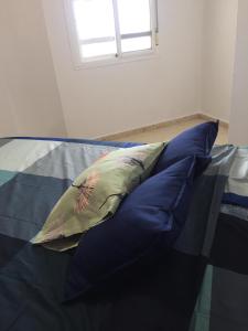 - une pile d'oreillers assises sur un lit avec une fenêtre dans l'établissement PISO 1ª LINEA SANLUCAR DE BARRAMEDA, à Sanlúcar de Barrameda