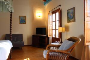 a bedroom with a bed and a chair and a tv at Sant Jaume in Alcudia