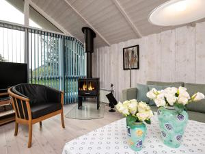 a living room with a fireplace and a table with flowers at 6 person holiday home in Thisted in Thisted