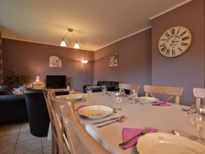 una sala da pranzo con tavolo e orologio sul muro di Alluring Holiday Home in Waimes with Garden a Waimes