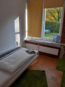 a bedroom with a bed and a window with a bench at Apartment Ground Floor Laatzen in Hannover