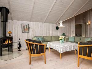 sala de estar con sofá, mesa y chimenea en 6 person holiday home in Thisted, en Thisted