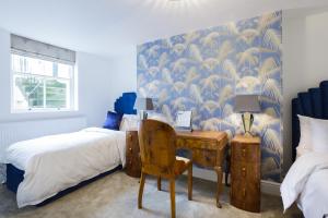 a bedroom with a bed and a desk with a chair at Sea-facing Art Deco Apartment in Brighton & Hove